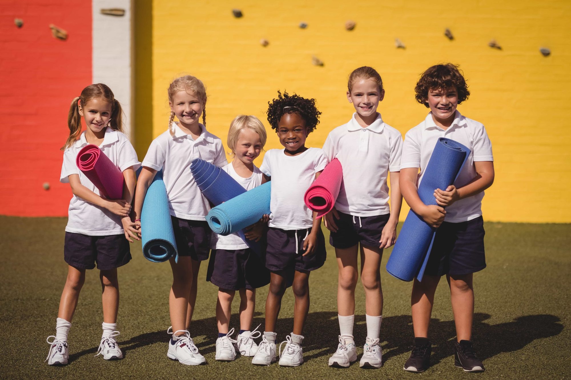 Pupils lined up against the school's yellow wall