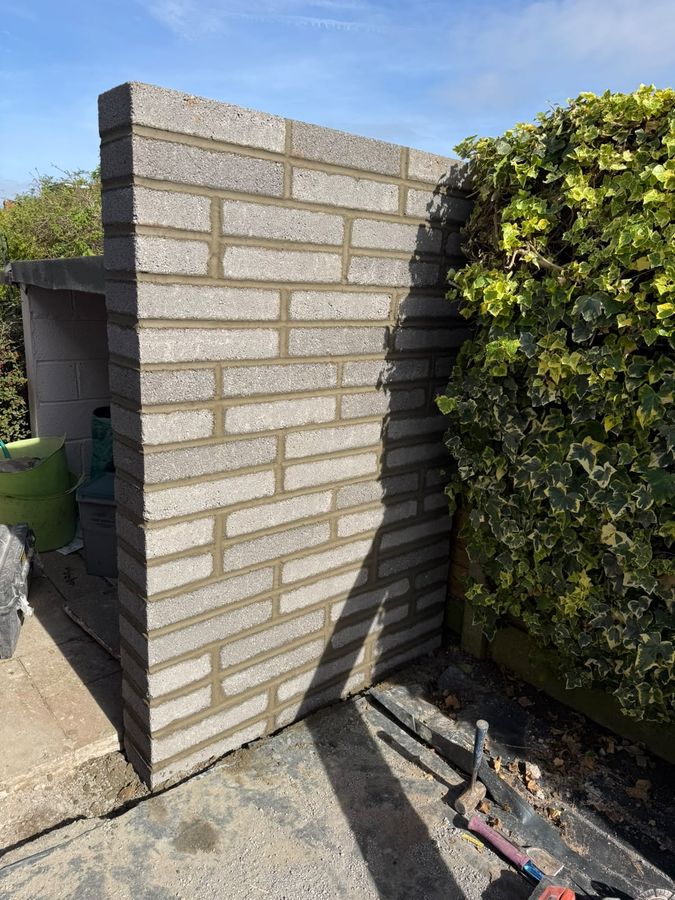 A new wall in buff facing brick, laid in stretcher bond and finished square at the return