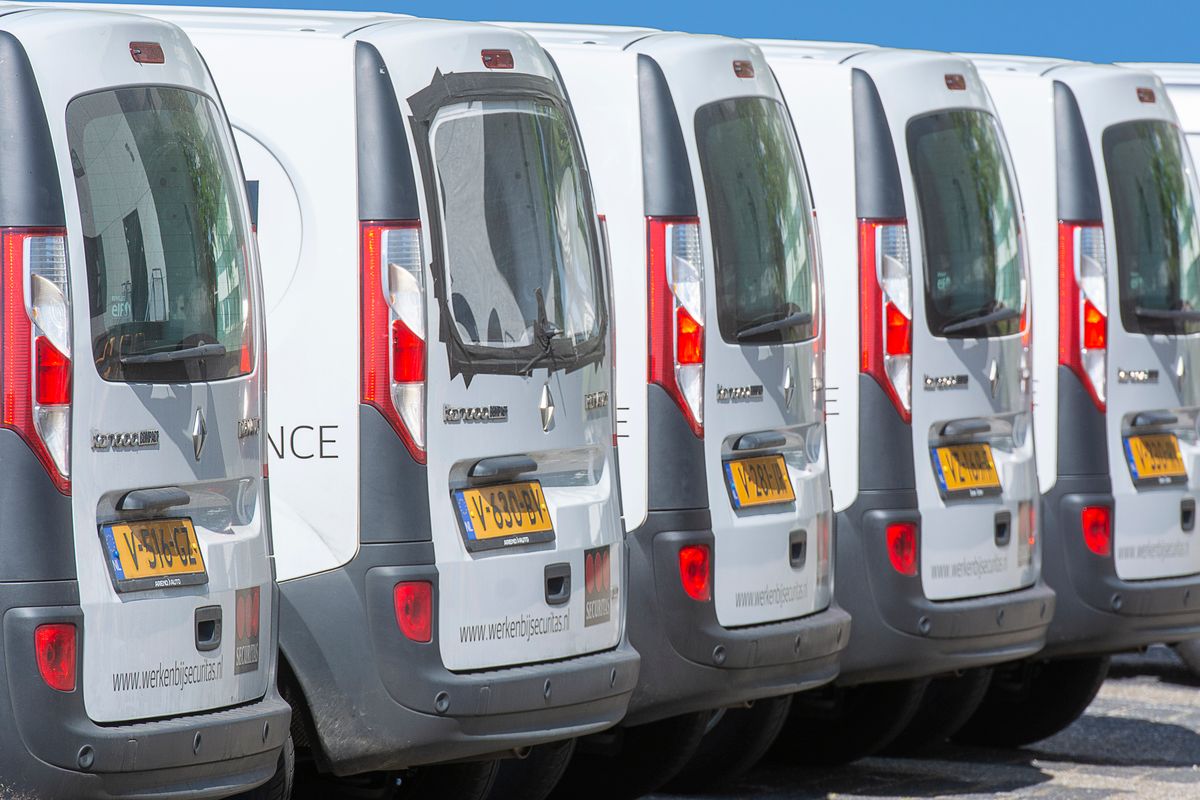 A row of panel vans photographed from behind, rear doors closed