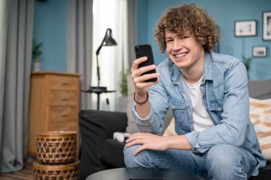 A smiling teenage boy with his phone