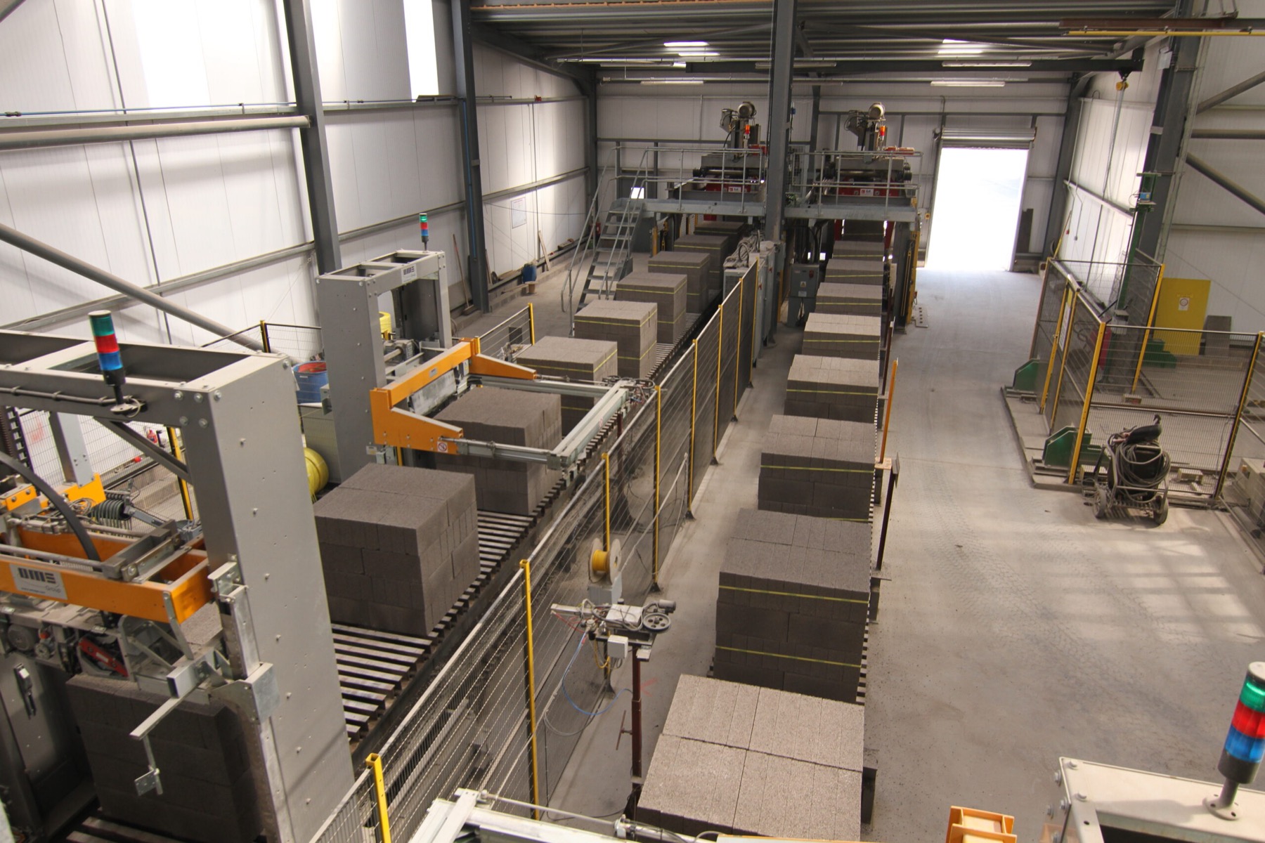 Newly pressed concrete blocks moving along the automated production line at the block plant