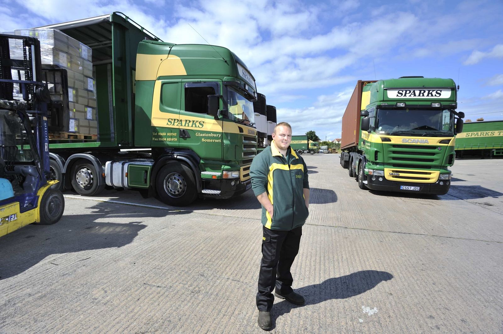 A Sparks driver walking across the yard beside the trucks