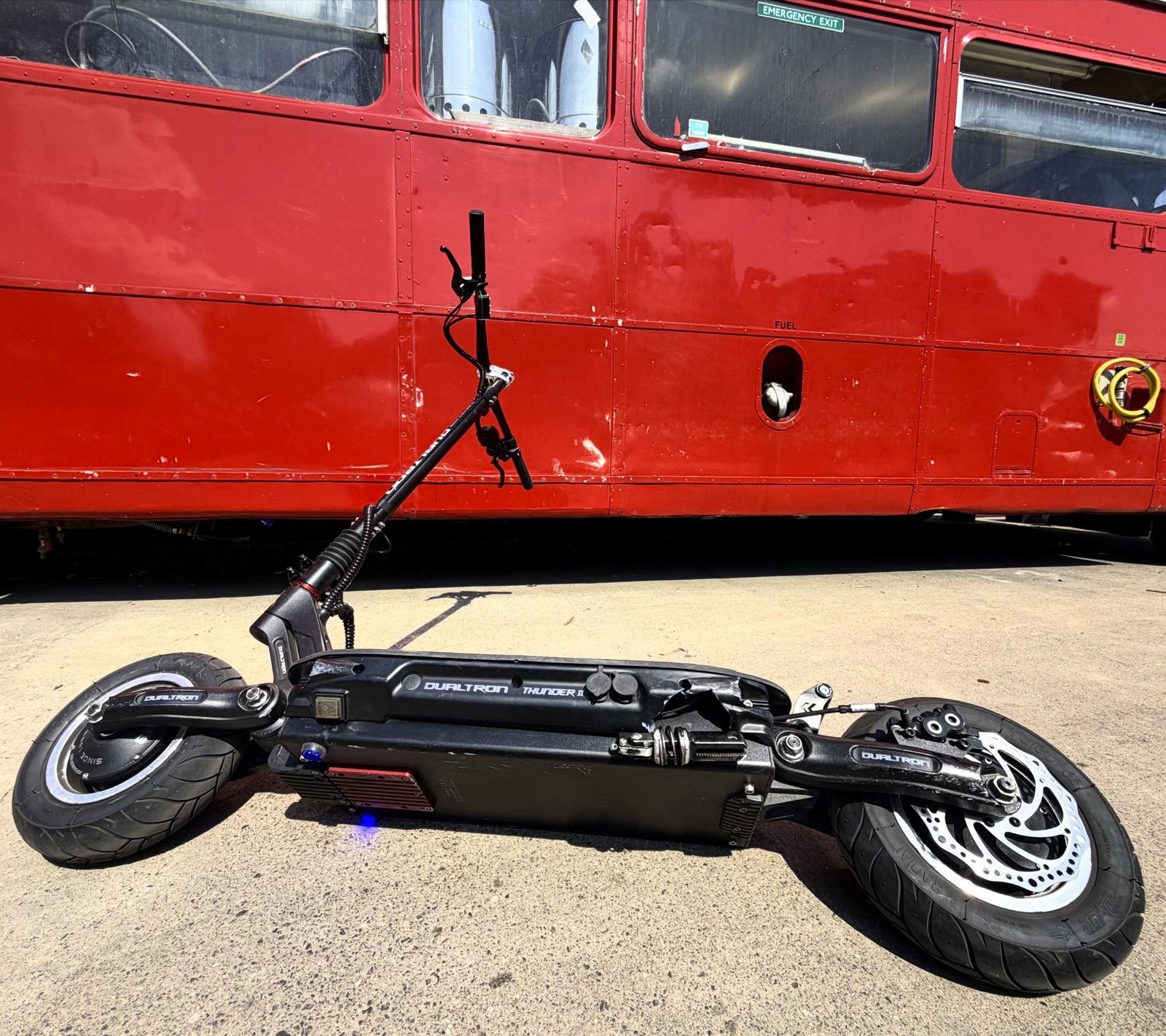 A Dualtron Thunder parked in front of a red Bristol bus